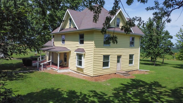 back of house with a patio area and a yard