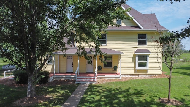 view of front facade featuring covered porch and a front yard