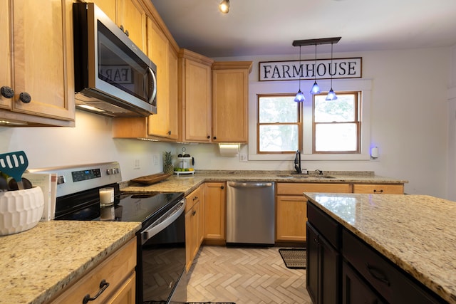 kitchen featuring sink, stainless steel appliances, light parquet flooring, and light stone counters