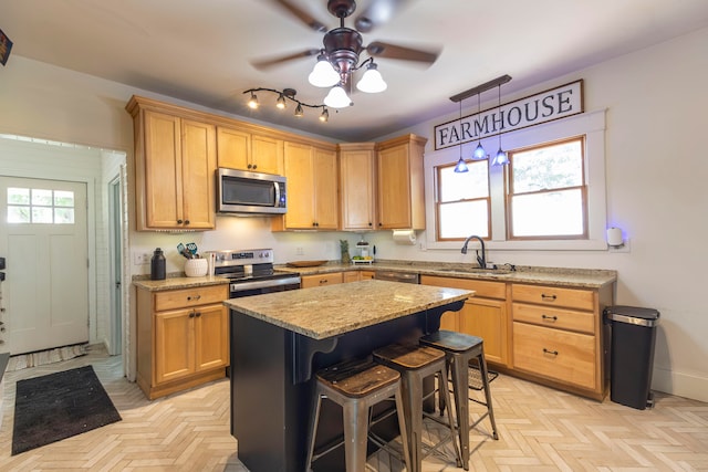 kitchen with ceiling fan, a kitchen island, appliances with stainless steel finishes, light parquet floors, and sink