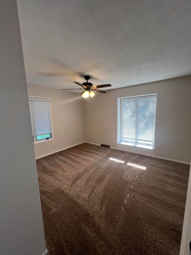 unfurnished room featuring ceiling fan, a textured ceiling, and carpet floors