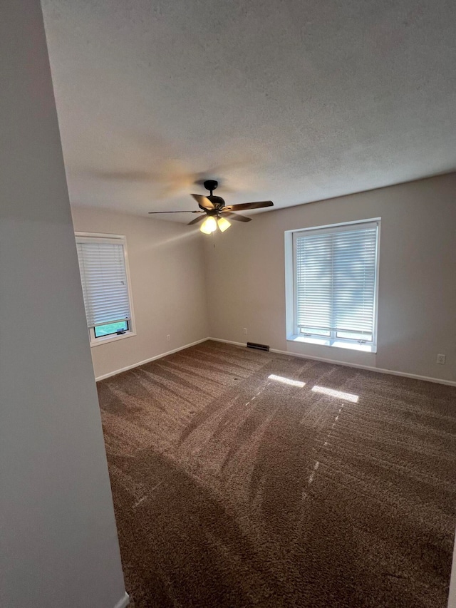 spare room with a textured ceiling, ceiling fan, and carpet floors