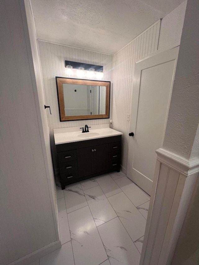 bathroom featuring vanity and wood walls