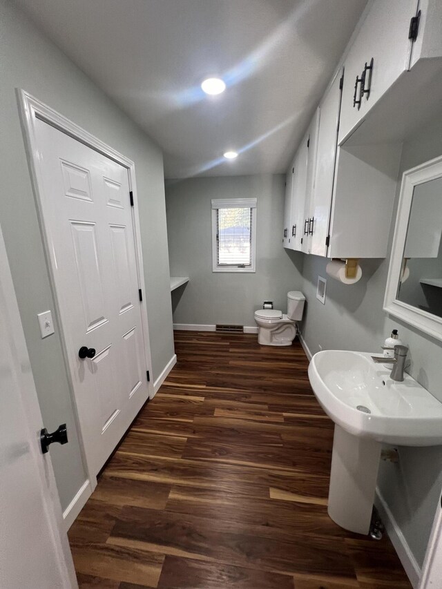 bathroom with toilet and hardwood / wood-style floors