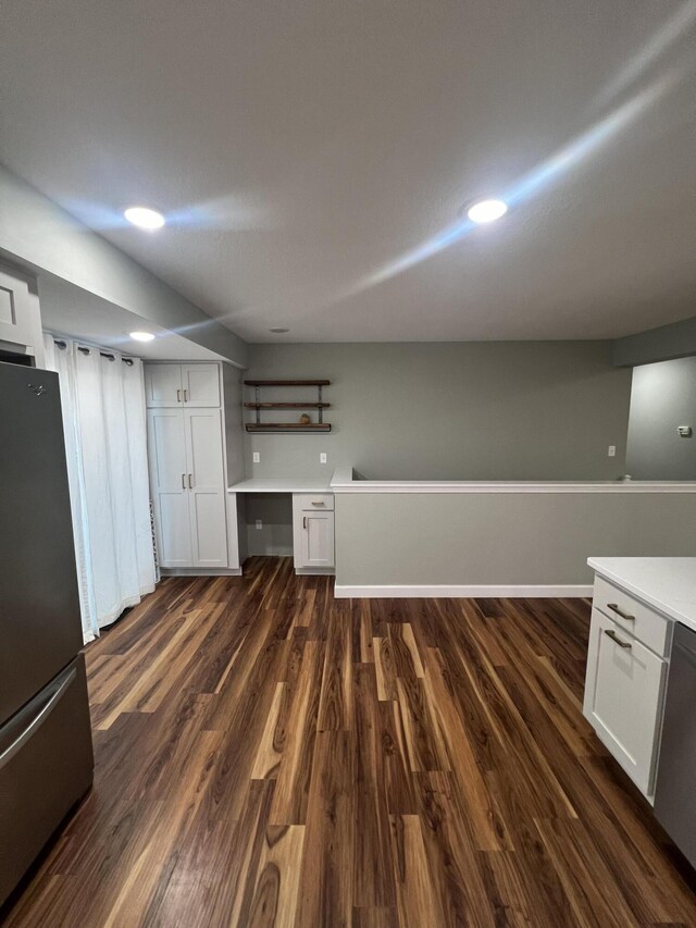 kitchen with stainless steel appliances, dark hardwood / wood-style floors, and white cabinetry