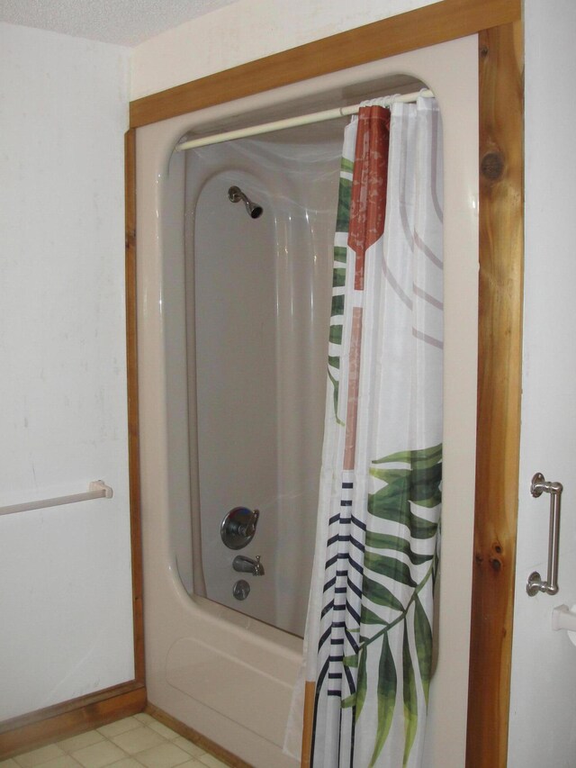 bathroom featuring a textured ceiling, shower / bathtub combination with curtain, and tile patterned flooring