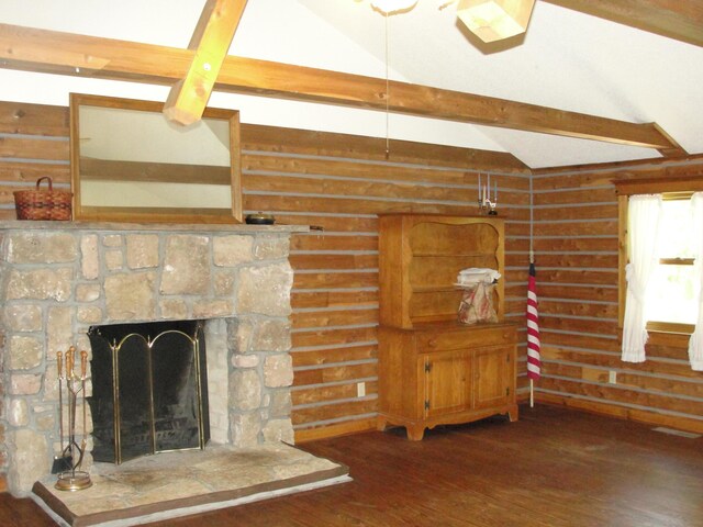 interior space featuring dark wood-type flooring, a fireplace, and vaulted ceiling with beams