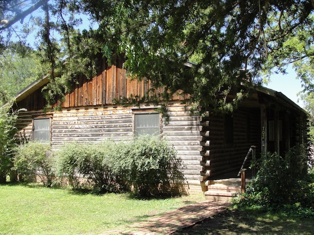 view of side of home with a yard