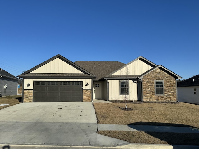 view of front of property featuring an attached garage, stone siding, board and batten siding, and concrete driveway