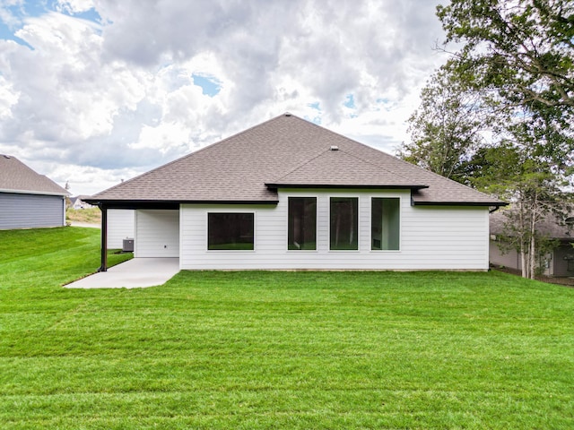 back of property with a lawn, central AC unit, and a patio area