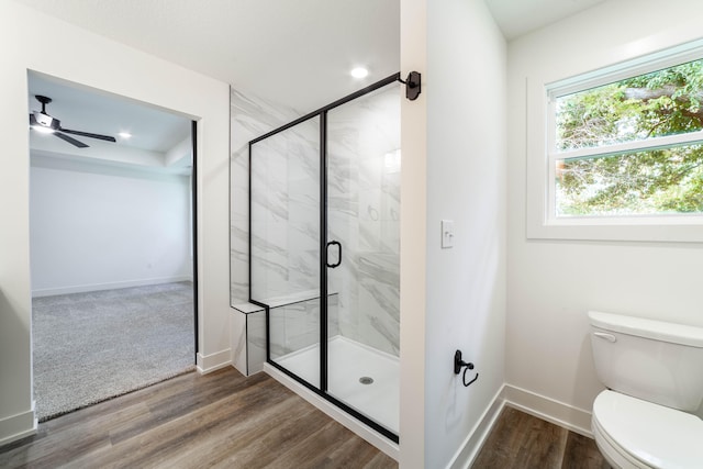 bathroom with ceiling fan, hardwood / wood-style floors, toilet, and an enclosed shower