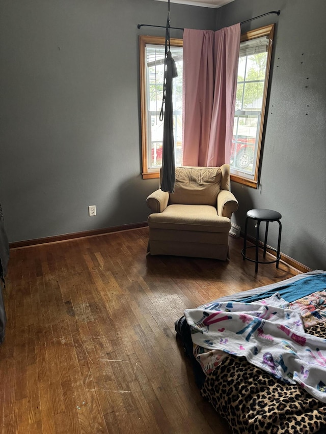 bedroom with hardwood / wood-style floors and multiple windows