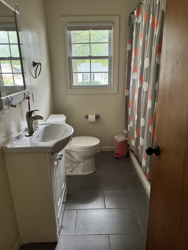 bathroom with toilet, tile patterned floors, and vanity