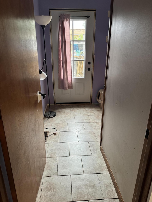 doorway to outside featuring light tile patterned flooring