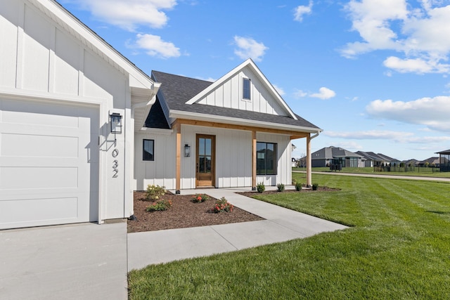 view of front facade with a front lawn, a garage, board and batten siding, and roof with shingles