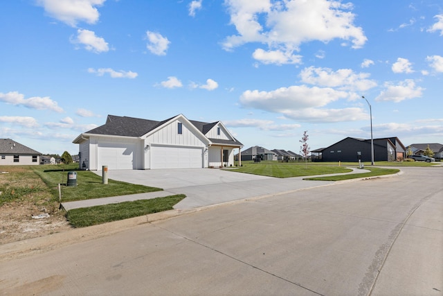 view of front of house with a front yard, concrete driveway, an attached garage, board and batten siding, and a residential view