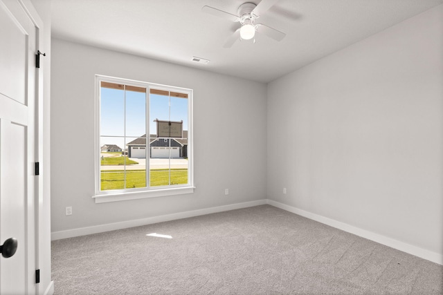 carpeted spare room featuring ceiling fan