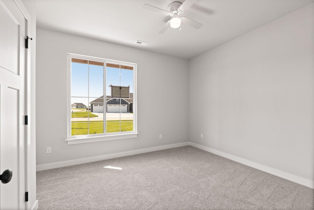 empty room featuring baseboards, visible vents, carpet floors, and a ceiling fan