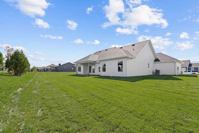 back of property with a lawn and central air condition unit