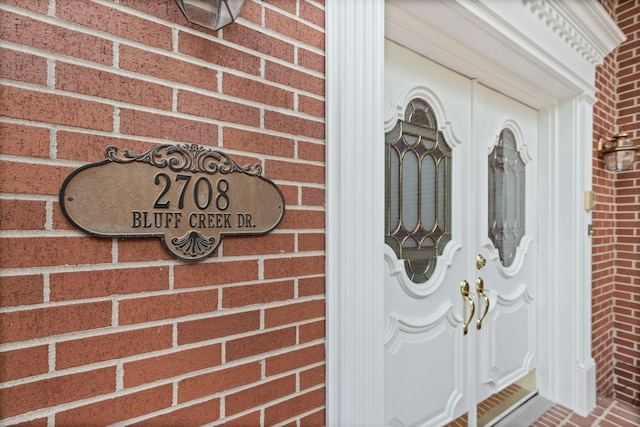 property entrance featuring brick siding