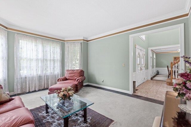 living room featuring plenty of natural light, baseboards, crown molding, and light colored carpet