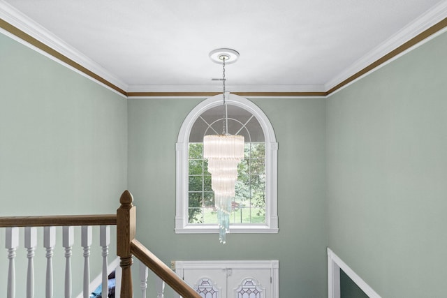 staircase featuring ornamental molding and an inviting chandelier