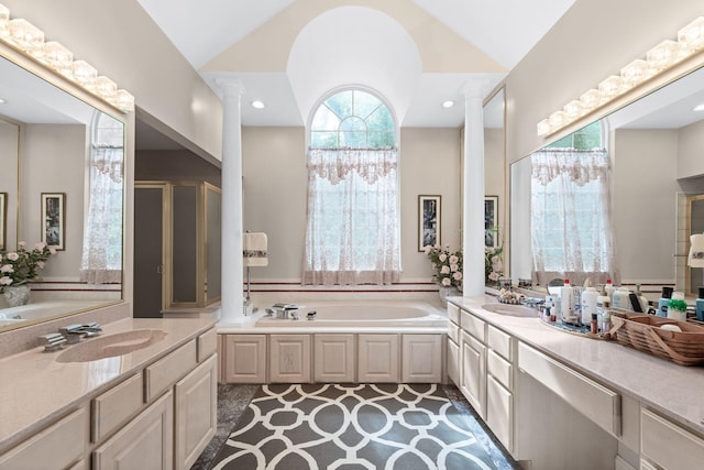 bathroom with lofted ceiling, vanity, recessed lighting, and a bath