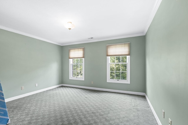 spare room with carpet, visible vents, crown molding, and baseboards