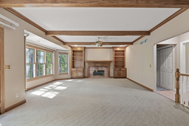 unfurnished living room with visible vents, a premium fireplace, baseboards, and beamed ceiling