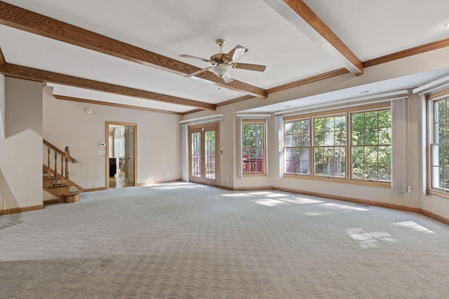 unfurnished living room with a healthy amount of sunlight, stairs, beamed ceiling, and light colored carpet