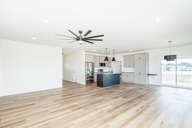 unfurnished living room with ceiling fan, a sink, light wood-style flooring, and recessed lighting