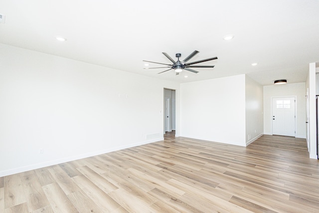 spare room with baseboards, light wood-style flooring, and recessed lighting