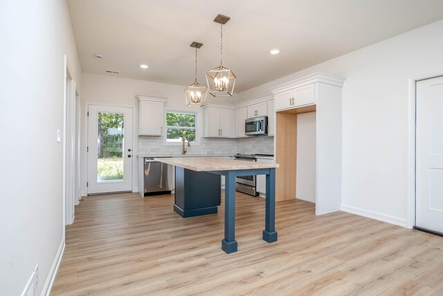 kitchen with a center island, a breakfast bar, light hardwood / wood-style floors, and stainless steel appliances