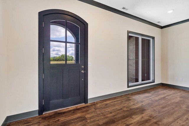 foyer entrance with crown molding and dark hardwood / wood-style flooring