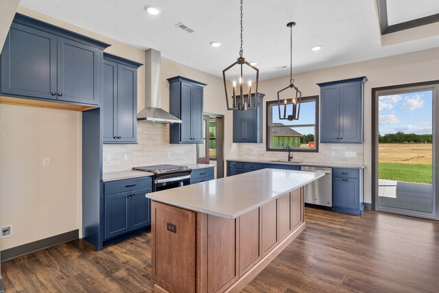 kitchen featuring wall chimney range hood, dark wood-type flooring, dishwasher, and a healthy amount of sunlight