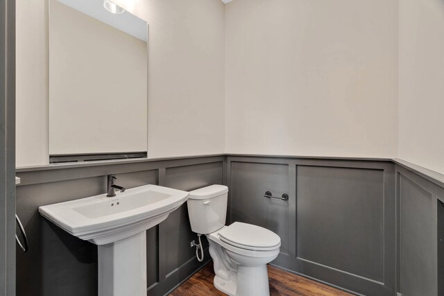 bathroom with toilet and hardwood / wood-style floors