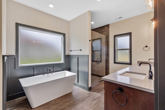 bathroom with shower with separate bathtub and vanity