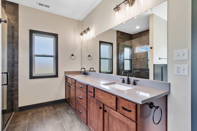 bathroom featuring vanity, tile patterned flooring, a healthy amount of sunlight, and a shower with door