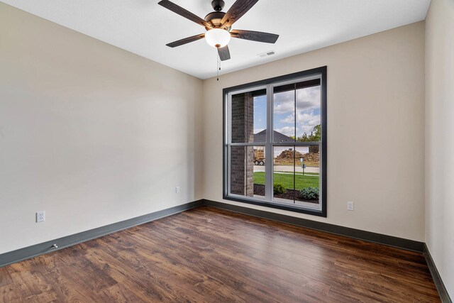 spare room with dark wood-type flooring and ceiling fan