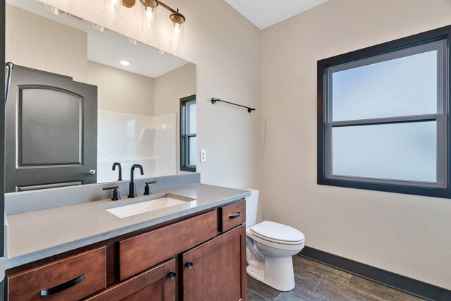 bathroom with vanity, toilet, and plenty of natural light