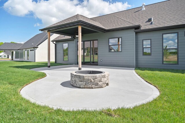 back of property with a patio area, a lawn, and an outdoor fire pit