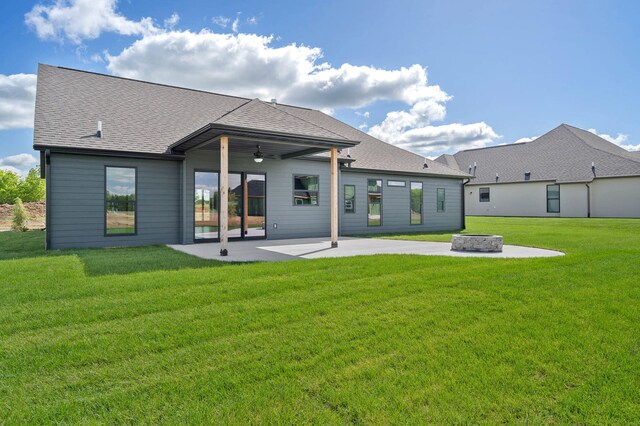 back of property with ceiling fan, a yard, and a patio