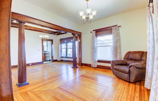 sitting room featuring a notable chandelier, light hardwood / wood-style floors, and decorative columns