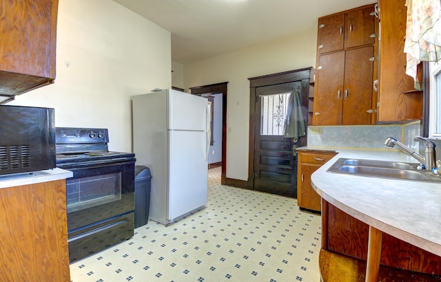 kitchen featuring white refrigerator, black range with electric cooktop, and sink