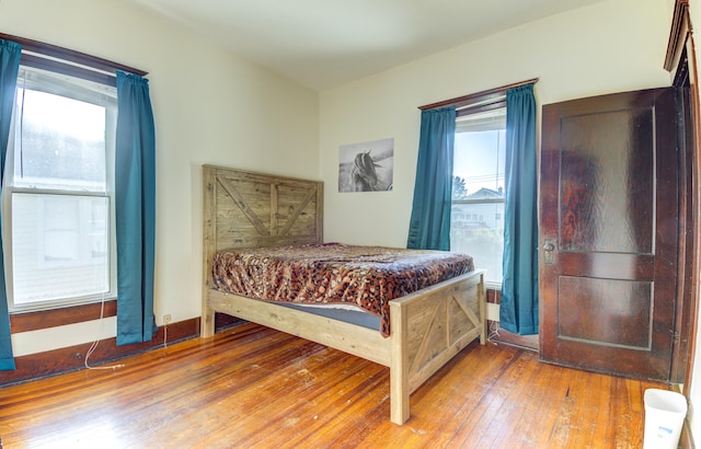 bedroom featuring wood-type flooring and multiple windows