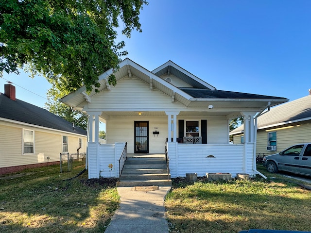 bungalow with a front yard and a porch