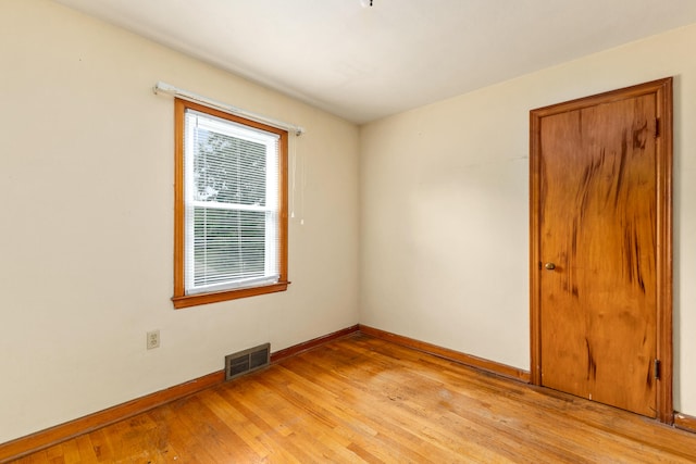 empty room with light hardwood / wood-style floors and a healthy amount of sunlight