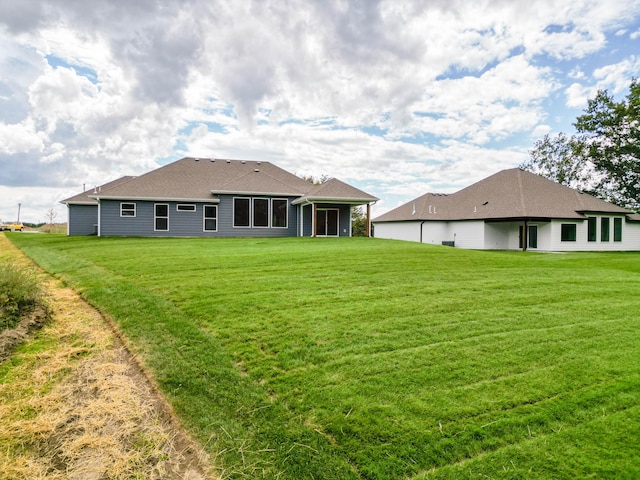 rear view of property featuring a yard