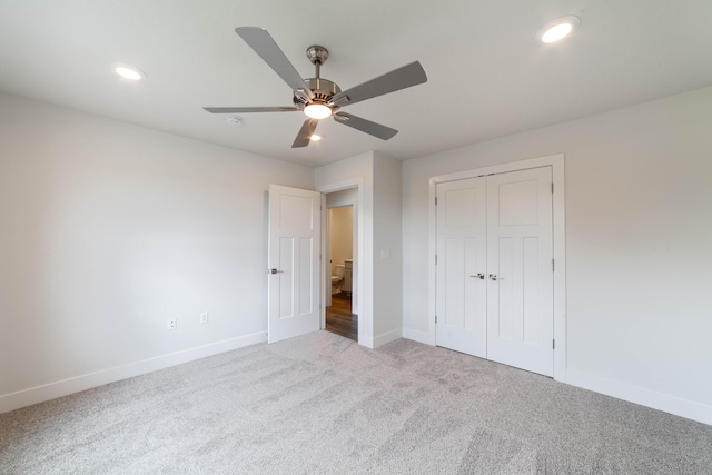 unfurnished bedroom with a closet, ceiling fan, and light colored carpet