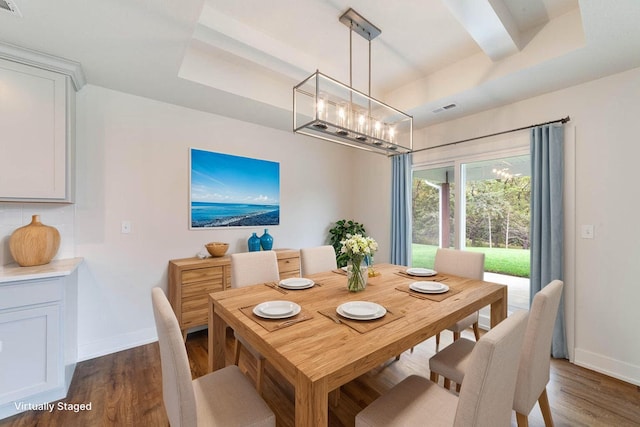 dining area featuring a tray ceiling and dark hardwood / wood-style floors